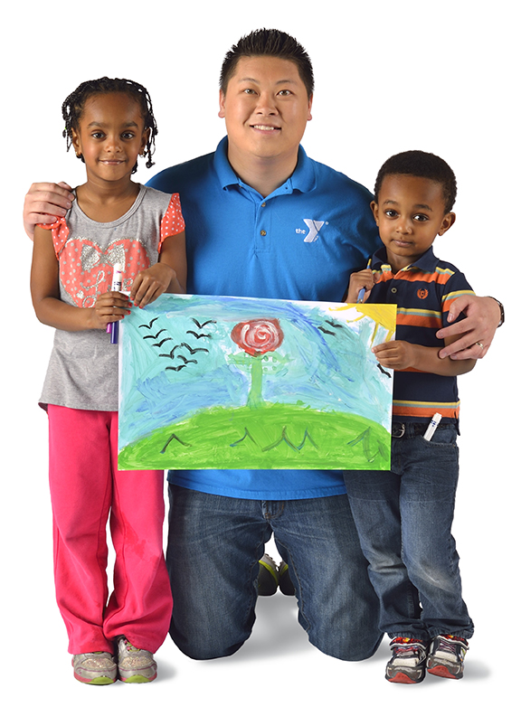 a photo of a man hugging two kids while holding a drawing with colorful colors 