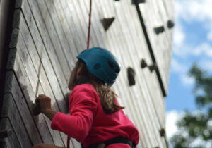 a photo of a child doing a mountain climbing on a wall