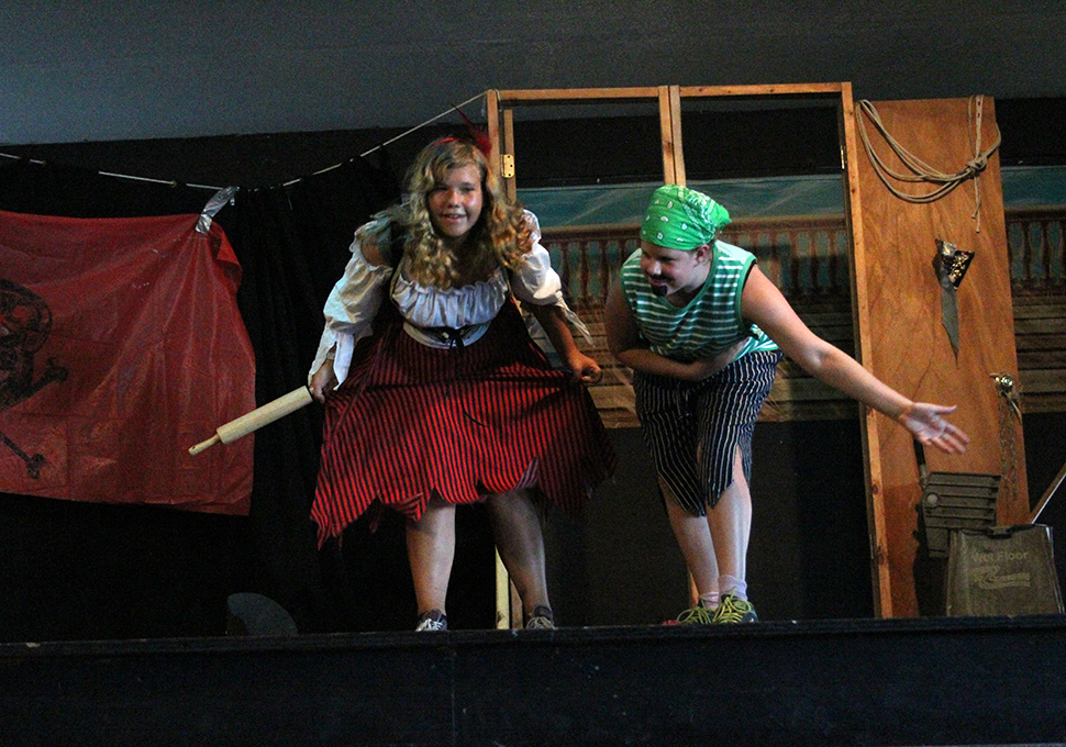 a photo of a girl and boy dressed up playing an act on a stage