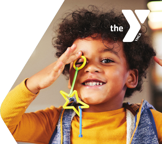 happy YMCA kid - a picture showing a smiling child with curly hair wearing an orange sweater
