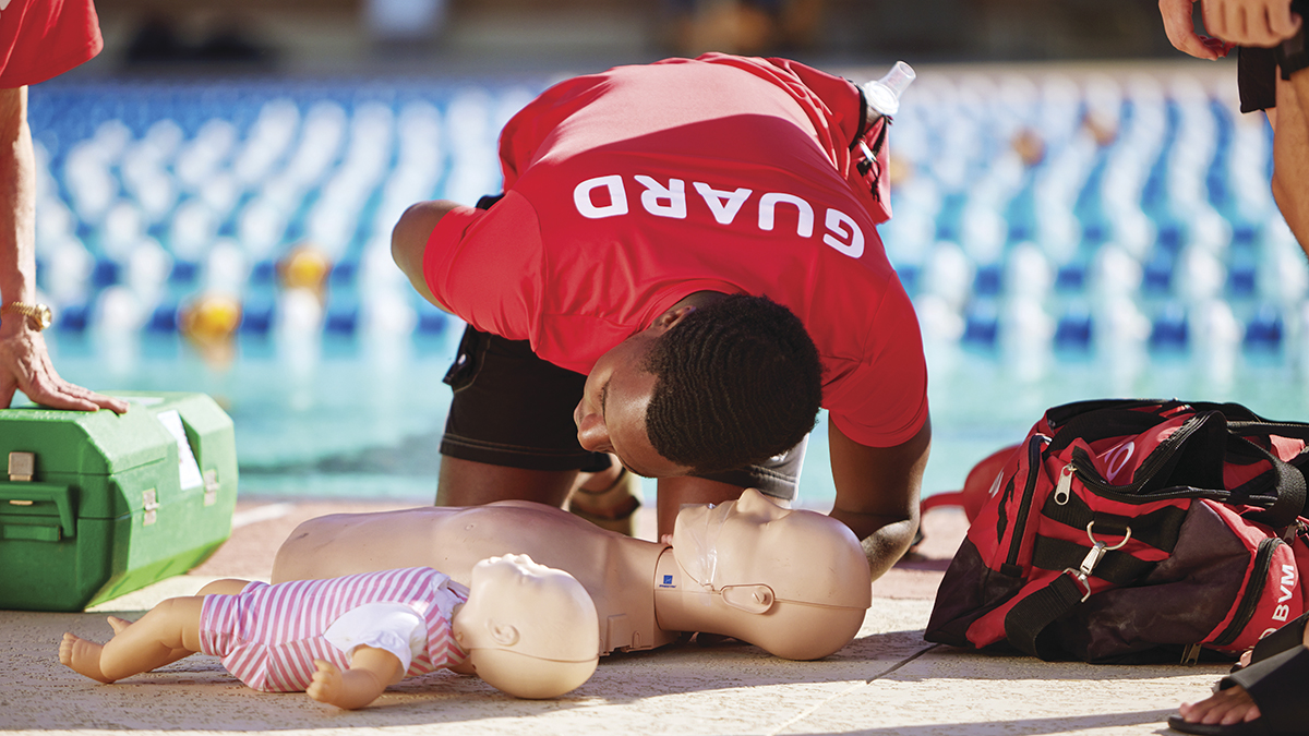 YMCA Lifeguard demonstrating on a CPR dummy during CPR and AED training