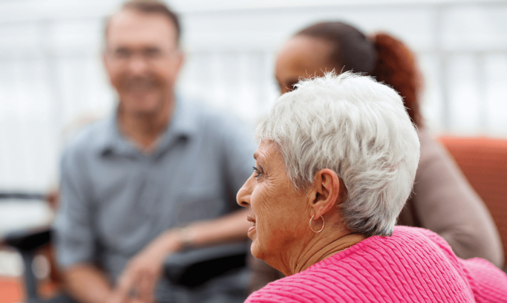 a photo of an elderly white-haired woman with people around her