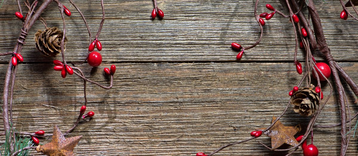 a decorative background of grayed wood and a twig wreath with red berries