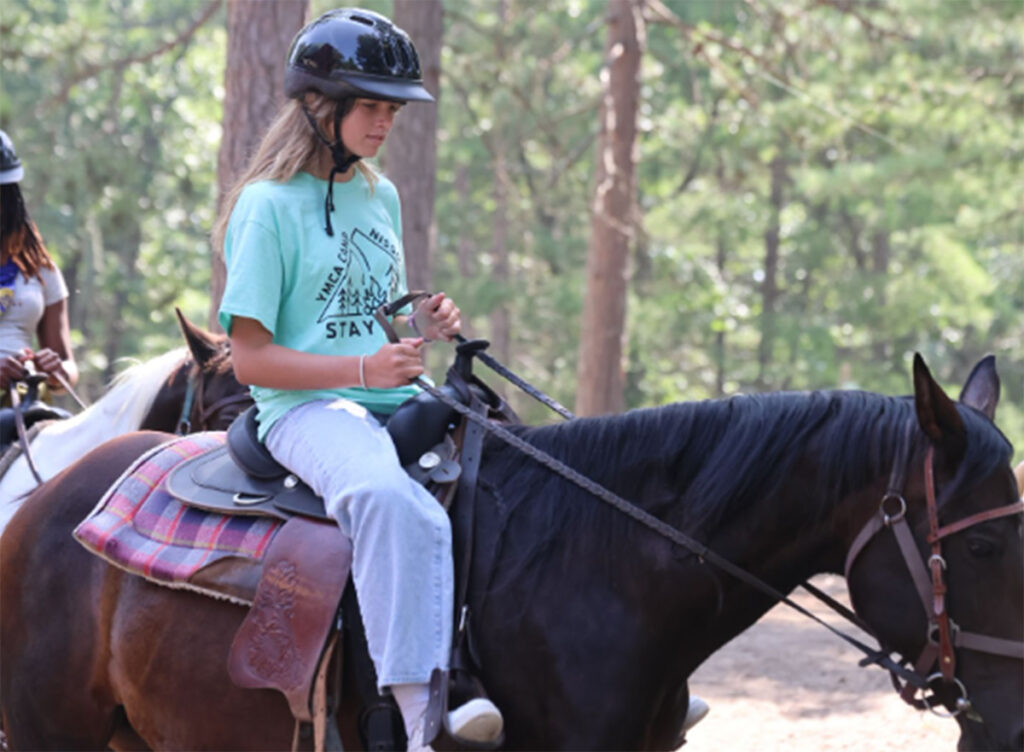 a camper riding a horse at YMCA Camp Nissokone